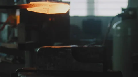 Blacksmith placing and hammering smelted metal on an anvil Stock Footage 275506428