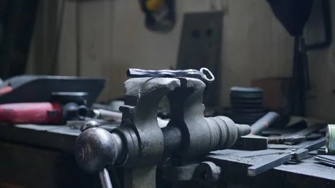 Blacksmith Placing Hot Metal on Bench Vise to Cool – Workshop Scene Stock Footage 313850817