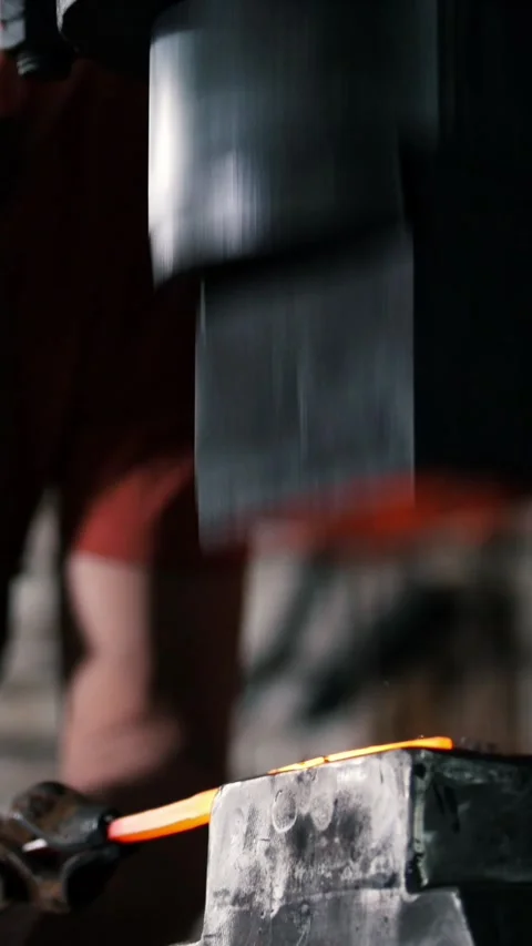 Blacksmith power hammer forging a hot metal bar Stock Footage 332614239