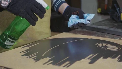 Blacksmith preparing decorative metal detail for paint at his workshop Stock Footage 83853262