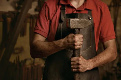 Blacksmith with professional heavy hammer in workshop Stock Photos