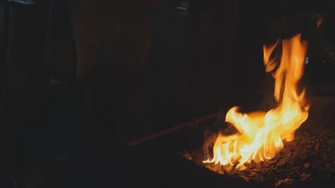 Blacksmith Pulls a Red Hot Iron with Sparks from a Fire Stock-Footage 108127855