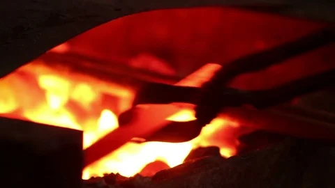 Blacksmith puts the iron into the fire Stock Footage 72219747