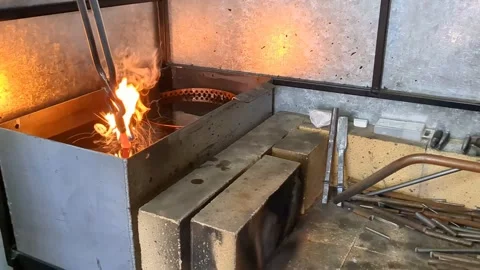 Blacksmith quenching hot glowing metal in fluid tank Stock Footage 344856743