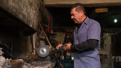 Blacksmith Sharpening Axe In Workshop With Grinder Sparks, August 20,2021, Stock Footage 324566839