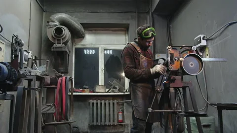 A blacksmith sharpens a knife in a workshop Video stock 167680378