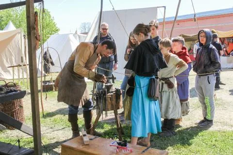 Blacksmith at the small anvil with a tool. Stock Photos