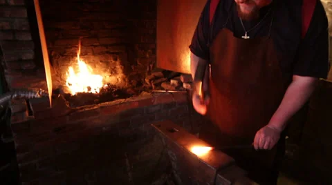 Blacksmith strikes red hot iron, sparks fly, medium shot Stock Footage 39022544