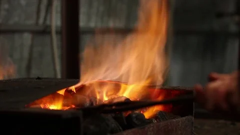 Blacksmith takes metal out of fire Stock Footage 72219702