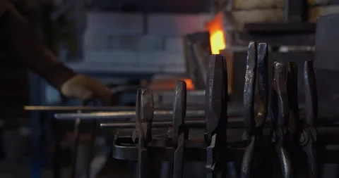 The blacksmith takes out a red-hot workpiece from the furnace Video stock 144518415