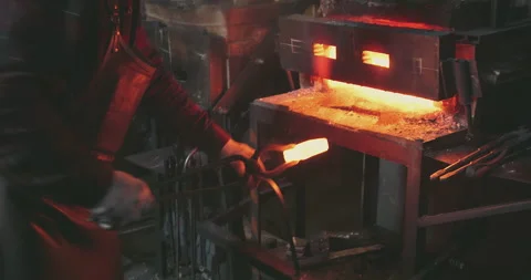 The blacksmith takes out the red-hot metal from the furnace Video stock 165440589