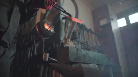 Blacksmith taking out hot knife from the forge and hardening steel in an oil. Stock Footage 194485756