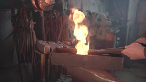 Blacksmith taking out hot knife from the forge and hardening steel in an oil. Stock Footage 194485914
