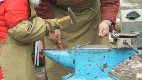Blacksmith teaching small girl how to do smithing Vídeo Stock 71694027