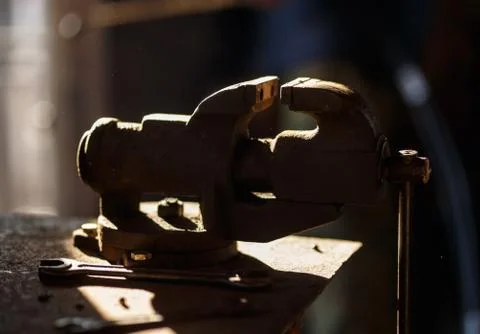 Blacksmith tools. Backlighted old vise in a forge shop Stock Photos
