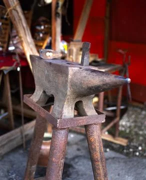 Blacksmith tools set with heavy iron anvil hammer and tongs on workbench Stock Photos