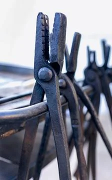 Blacksmith tools set with heavy iron anvil hammer and tongs on workbench Stock Photos