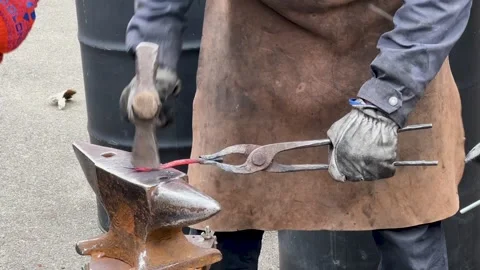 Blacksmith uses a hammer to forge metal A male blacksmith forges hot metal with Stock Footage 270177738
