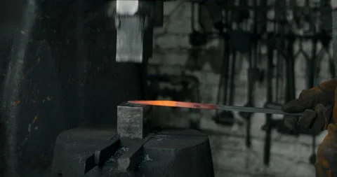 Blacksmith uses a hydraulic hammer to forge hot metal in his workshop, automatic Stock Footage 151541597