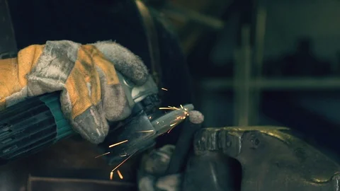 Blacksmith using an angle grinder in the workshop Stock Footage 128597346
