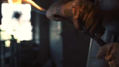 Blacksmith using a blowtorch and heating a metallic object Stock Footage 128597601