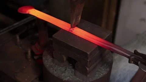Blacksmith using a chisel to carve hot iron Stock Footage 133954370