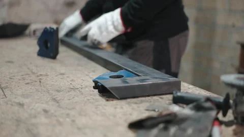 Blacksmith using cut and polished metal bars to form perfect steel construction Stock-Footage 262564822