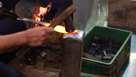 Blacksmith using hammer  to make blade from hot metal in workshop Video stock 251707397