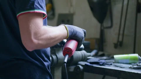 Blacksmith Using Handheld Grinder – Rear View with Flying Sparks Stock Footage 313846754