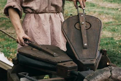 Blacksmith using pair of bellows to kindle fire in furnace Stock Photos