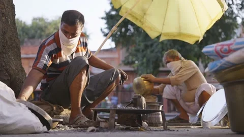 A blacksmith wearing face protective masks are working in a busy market Stock Footage 147010870