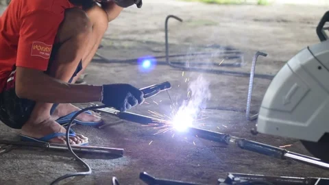 Blacksmith welder in protective mask works with metal steel and iron using a  Stock Footage 149900173