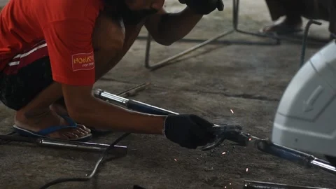 Blacksmith welder in protective mask works with metal steel and iron using a  Stock Footage 149900201