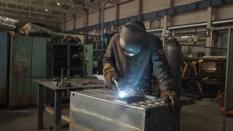 Blacksmith welder in protective mask works with metal using a welding machine Stock Footage 150733730