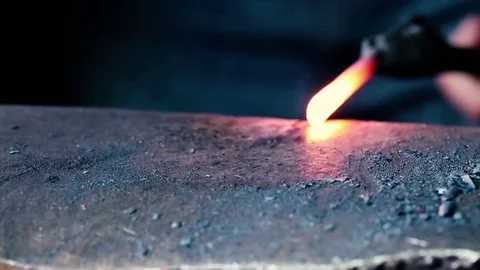 Blacksmith work. Blacksmith beats a piece of white hot metal with a hammer on an Stock Footage 76373368