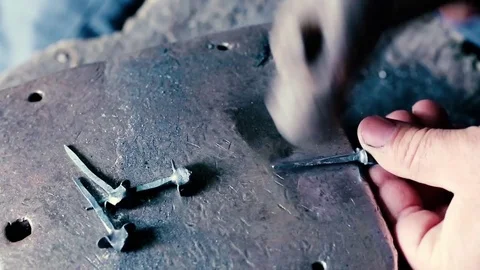 Blacksmith work. Blacksmith beats a piece of white hot metal with a hammer on an Stock Footage 76373768