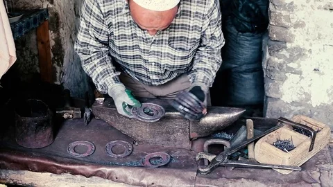 Blacksmith work. Blacksmith beats a piece of white hot metal with a hammer on an Stock Footage 76374003