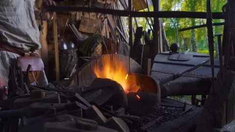 Blacksmith working with blacksmith furs in forge. Hot metal part in fire. Stock Footage 108826435