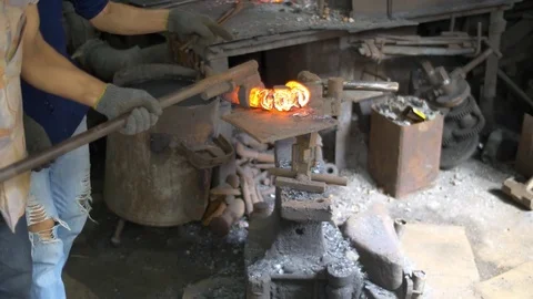 Blacksmith working with hot glowing metal, bending steel in a smithery. Stock Footage 71392262