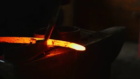 Blacksmith working with hot glowing metal, bending steel in a smithery Stock Footage 79148639