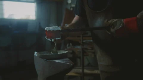 Blacksmith working with hot metal and borax powder in a forge Stock Footage 275167609