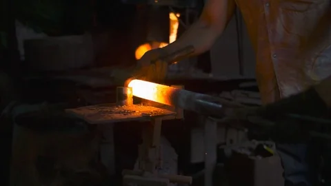 Blacksmith working in a smithery forging glowing hot metal and sparks fly Stock Footage 71391178