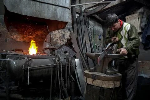 Blacksmith working in workshop Stock Photos