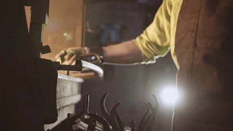 The blacksmith works next to the hot stove. Makes a knife. Working atmosphere. Stock Footage 108956492