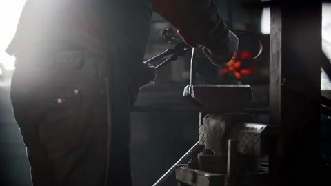 Blacksmith workshop - a man makes a notch on metal object using pressing machine Stock Footage 180497446