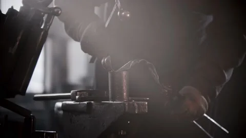 Blacksmith workshop - a man shaping heated metal by hitting it with a hammer Stock Footage 180505797
