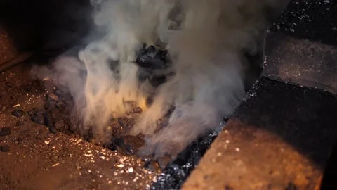 Blacksmithing forge. Thick white smoke from charcoal or coke in the hearth. Stock Footage 219956990