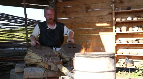 The blacksmith's assistant is working the bellows Stock Footage 54687948