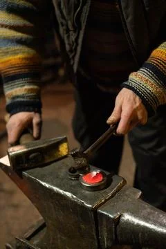 The blacksmith's hands forge a product of hot iron Stock Photos