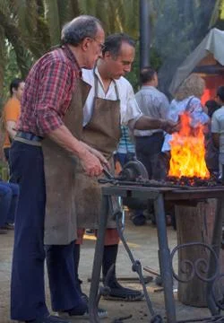 Blacksmiths working on metal  at forge 스톡 사진